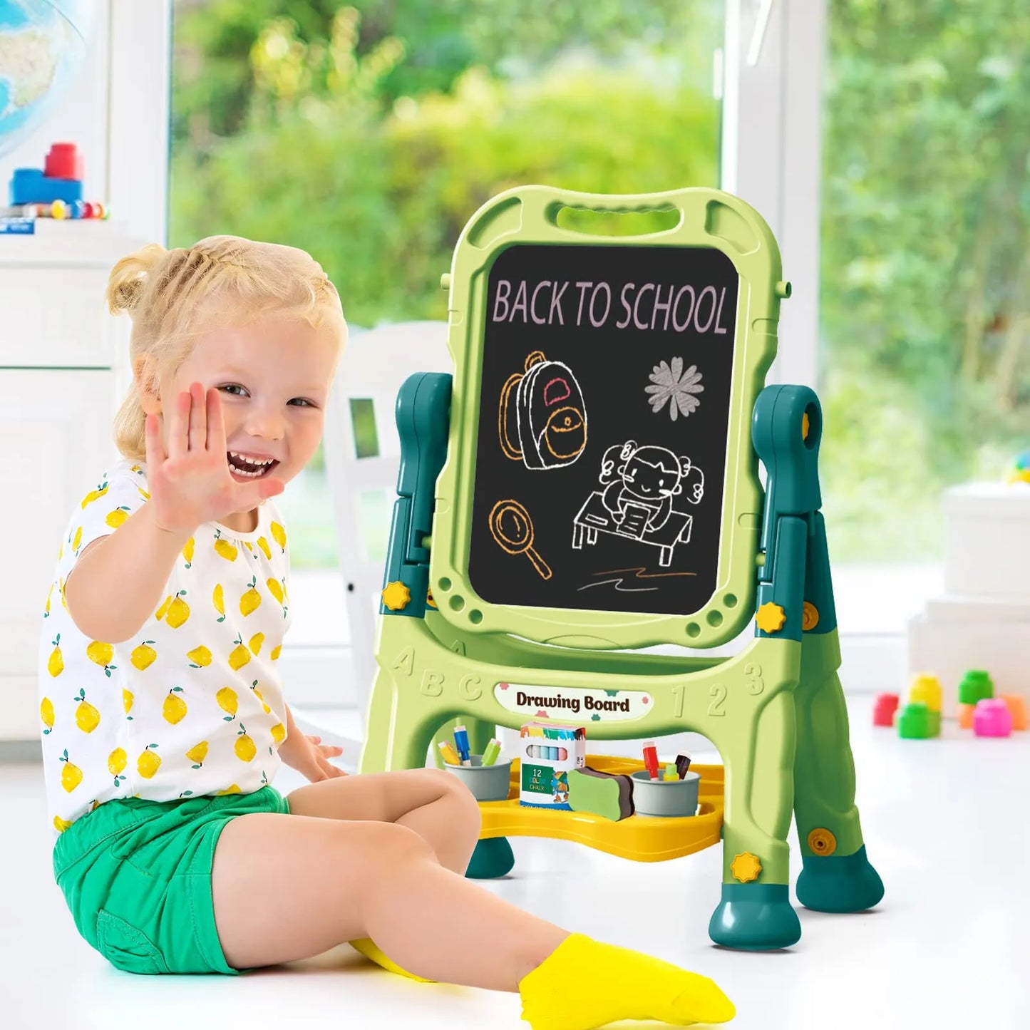Child sitting next to a green Learn-n-Draw Double Fun Board with ‘Back to School’ text and illustrations – kids drawing board by Tiny Toyland